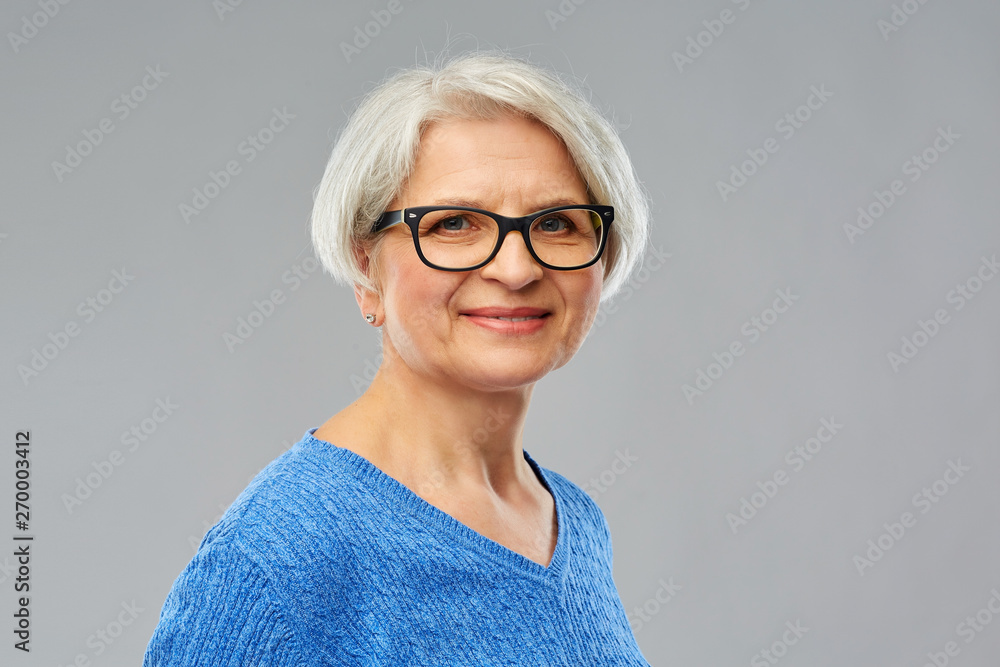 vision and old people concept - portrait of smiling senior woman in glasses over grey background