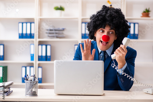 Young clown businessman working in the office  photo