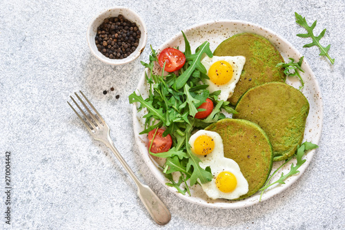 Tableau sur toile Morning breakfast: pancakes with spinach, salad and egg on the kitchen table