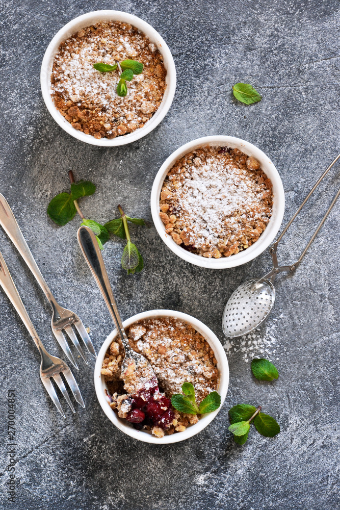 Cherry crumble with nuts and mint on a concrete background. Cherry crumble with nuts and mint on a concrete background.