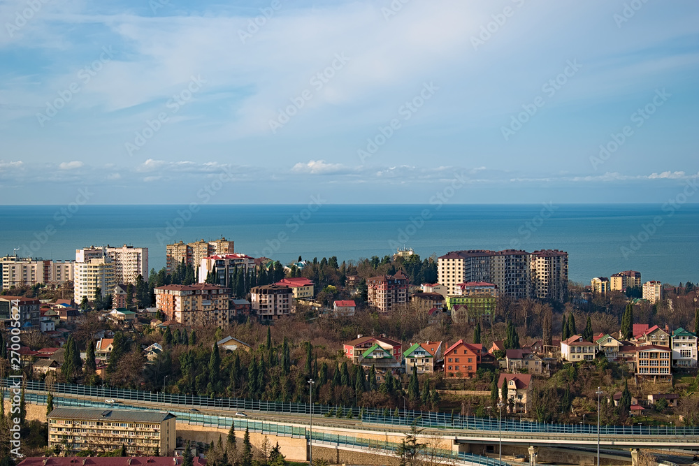 Obraz premium View from the window to the sea, the road and part of the city. In the summer, in Sunny weather with a few clouds.