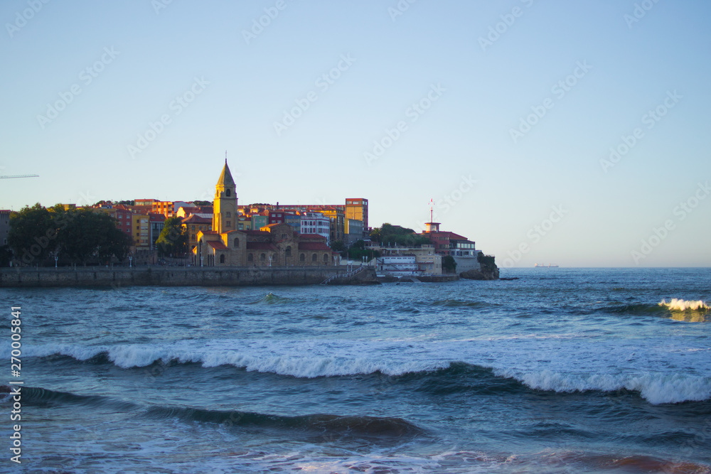 San Pedro's Church (Iglesia de San Pedro) with the Cantabrian Sea in San Lorenzo beach, Gijon, Asturias (Spain)