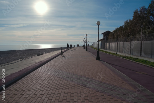 Beautiful alley along the sea with the beach. Sunset is very well in harmony with the sea, reflected from the sea water.