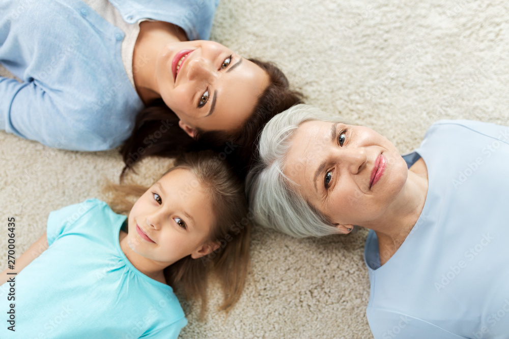 family, generation and female concept - mother, daughter and grandmother lying on floor from top