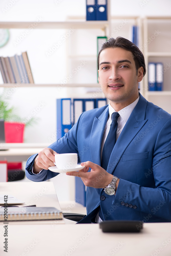 Young handsome employee in the office Young handsome employee in the office