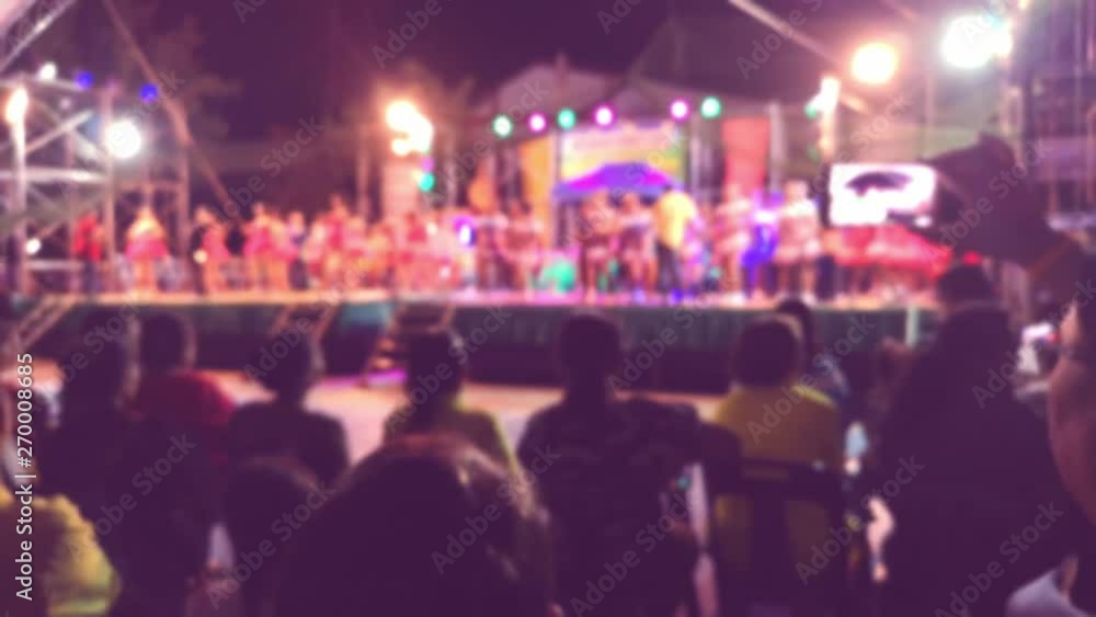 Blurred colorful of abstract people holding their smart phones and photographing concert. Young Asian traveler taking photo with mobile phone in pub and street road at night. Blurred colorful of abstract people holding their smart phones and photographing concert. Young Asian traveler taking photo with mobile phone in pub and street road at night.