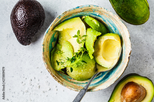 Peeled avocado halves in a bowl, top view. Cooking guacamole. photo