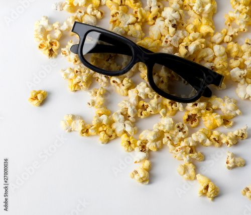 Popcorn and 3d glasses at white table. Flat lay