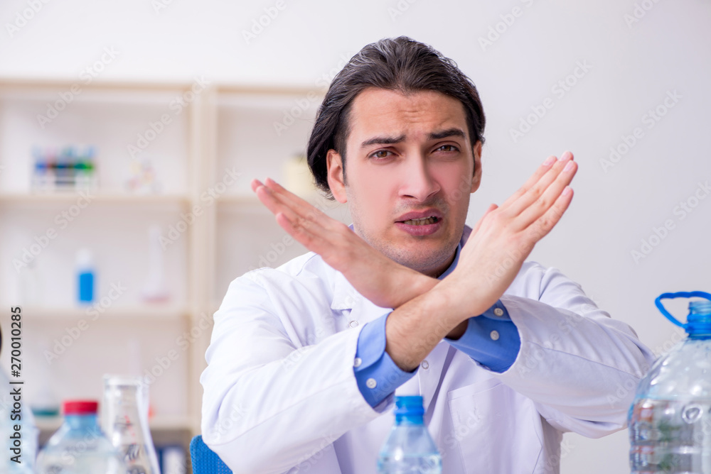 Young male chemist experimenting in lab Young male chemist experimenting in lab