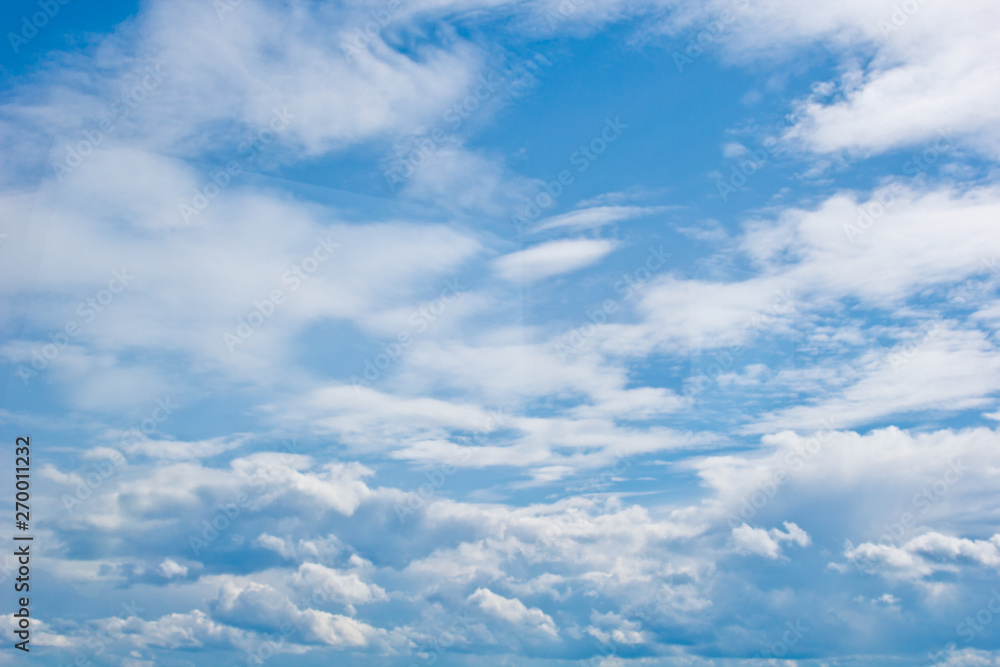 white cumulus clouds in the form of cotton wool on a blue sky. background, bright sky texture
