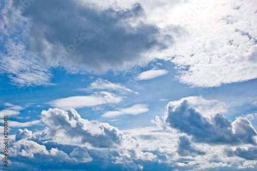 white cumulus clouds in the form of cotton wool on a blue sky. background, bright sky texture © Yuliia