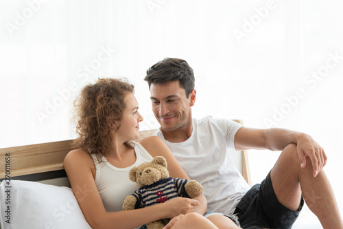 Happy couples relaxing in the white bedroom Of the apartment With various emotions With snacks, coffee, fruit in the morning