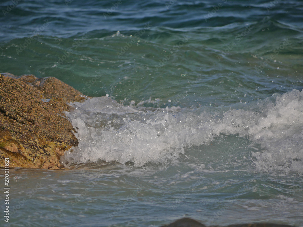Fototapeta premium Waves crashing against the rock