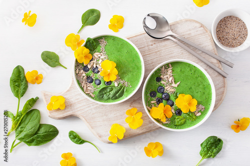 green spinach smoothie bowl with blueberry  chia seed and edible pansy flowers