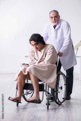 Old male doctor psychiatrist and patient in wheel-chair 