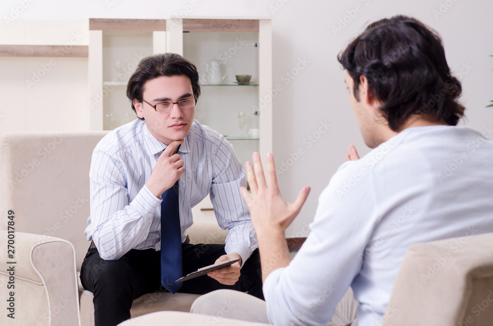 Obraz premium Young male patient discussing with psychologist personal problem