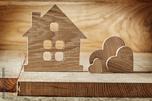 vintage wooden toys house and three hearts on wood background photo