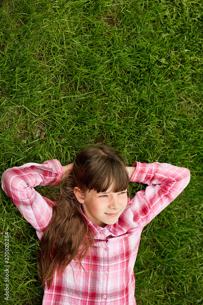 Relaxed teenage girl lying in grass. lifestyle, summer vacation and people concept. Relaxed teenage girl lying in grass. lifestyle, summer vacation and people concept.