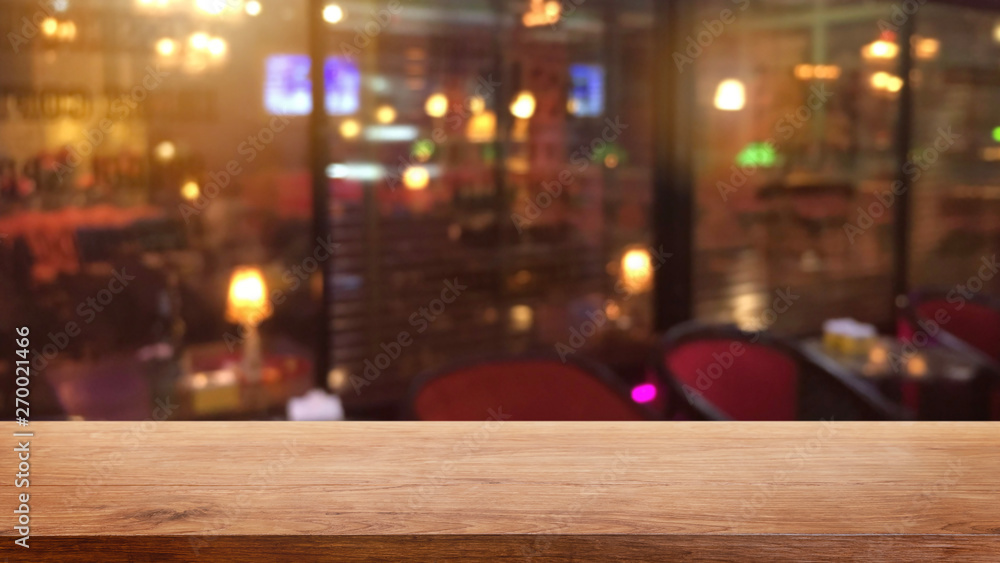 Empty wood table top on abstract blurred restaurant and nightclub lights background - can be used for display or montage your products