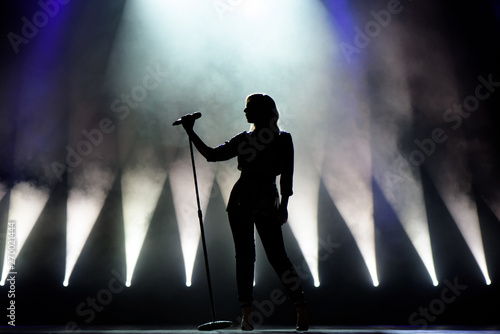 Vocalist singing to microphone. Singer in silhouette photo
