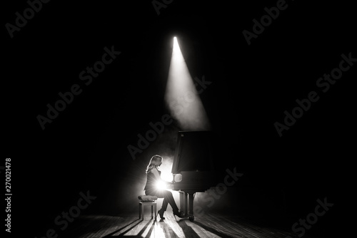 Quadro em tela Young musician playing the grand piano on the stage