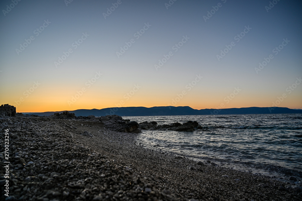 sunrise over a stone beach in Rabac Croatia sunrise over a stone beach in Rabac Croatia