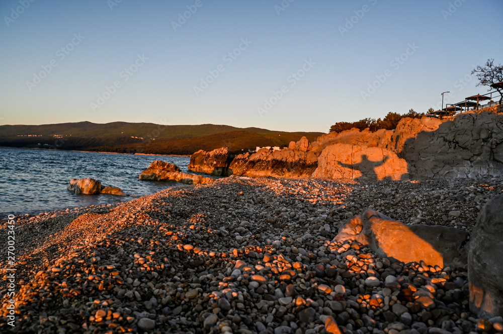 Naklejka premium sunrise over a stone beach in Rabac Croatia
