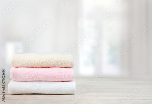 Stack of towels on wooden table empty space background.