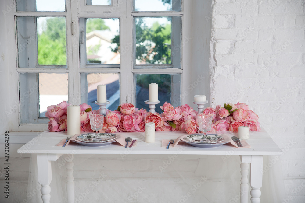 Wall Mural bouquet of pink orchids, roses and peons decorates the dining table near the win
