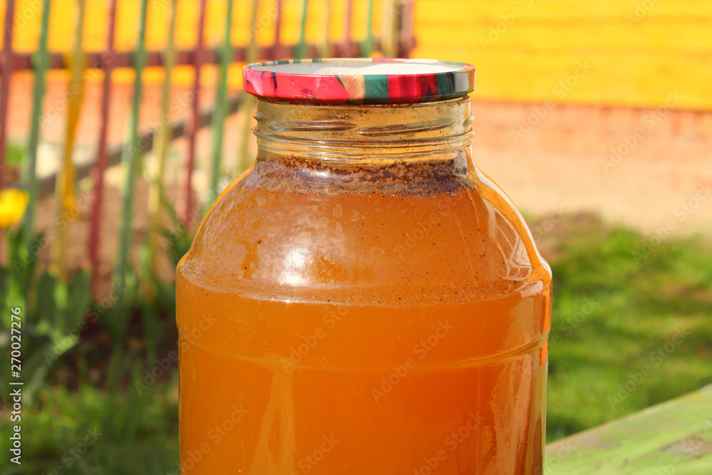 Fresh kvass in a glass jar in the garden. Close-up. Background. Fresh kvass in a glass jar in the garden. Close-up. Background.