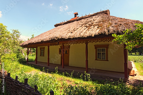 Wide angle landscape view of typical clay house called Shunok (tavern or bar). Pereyaslav-Khmelnitsky Museum of Folk Architecture and Life of the Middle Naddnipryanshchyna. Spring sunny day. Ukraine