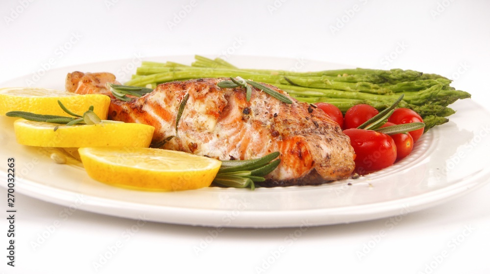 Grilled rosemary salmon served with asparagus, lemon, cherry tomatoes Grilled rosemary salmon served with asparagus, lemon, cherry tomatoes