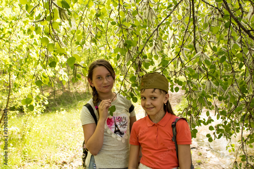 Girls are standing under a poplar tree. Poplar fluff. Girls are standing under a poplar tree. Poplar fluff.