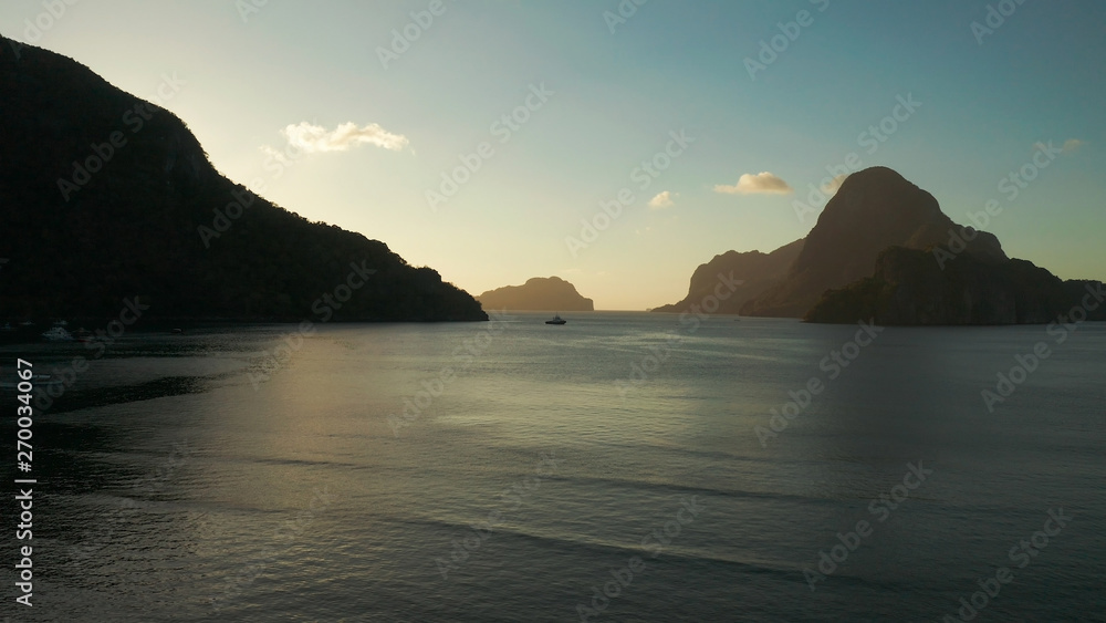 aerial view tropical bay in El Nido at sunset. Seascape with mountains and rocky islands in the morning time. sunset over the sea. Sunset sky and mountains rocks of bay. Dreamy sunset among the rocks.