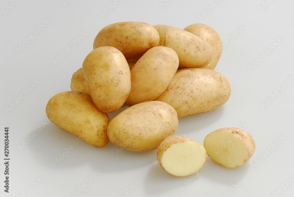 A lot of raw potatoes on a gray isolated background A lot of raw potatoes on a gray isolated background