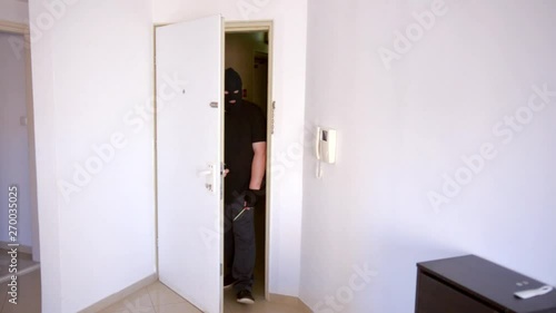 Few seconds are enough time for the thief in black clothes to have gained entrance of a residential apartment. photo