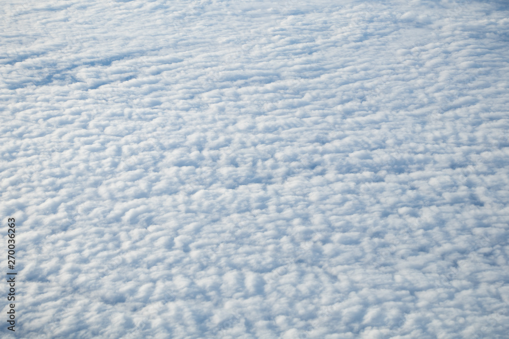 Aerial view from plane window with blue sky and white clouds Aerial view from plane window with blue sky and white clouds