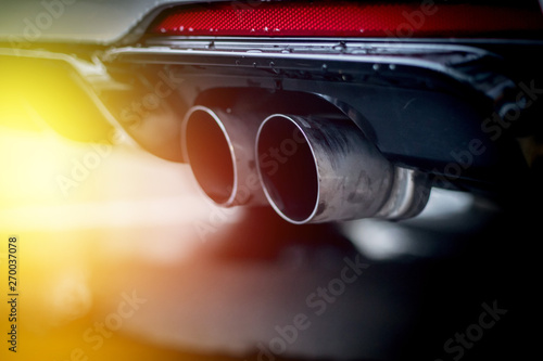 Powerful car with exhaust pipe, pollution and fine dust. Sunlight. photo