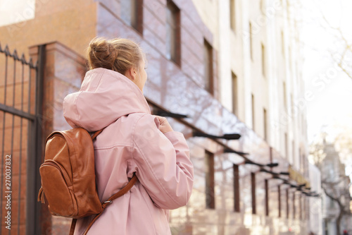 Young woman with backpack on city street