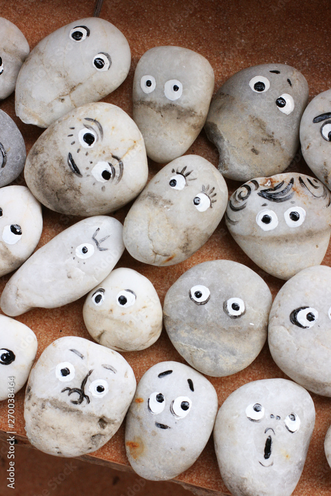 Stone decor for garden. Stones with funny faces. Allegory on society, group, friendship and teamwork