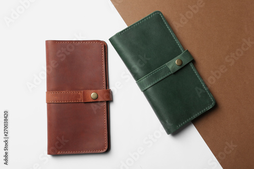 Stylish wallets on color background, top view