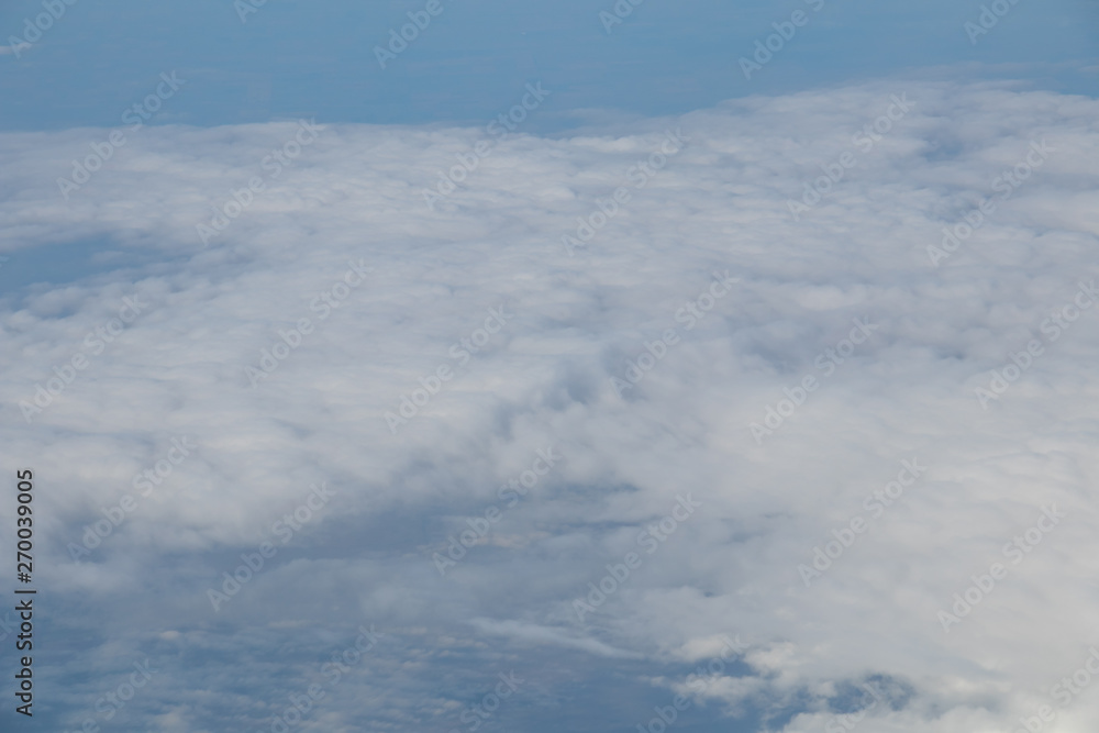 Aerial view from plane window with blue sky and white clouds Aerial view from plane window with blue sky and white clouds