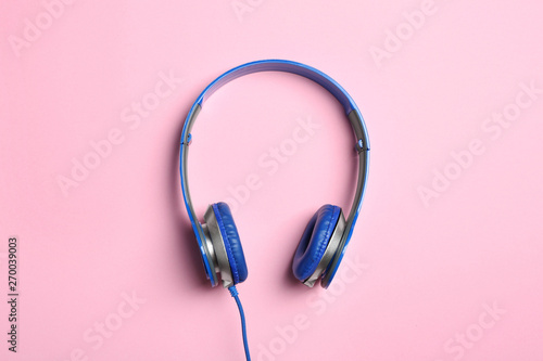 Stylish headphones on color background, top view