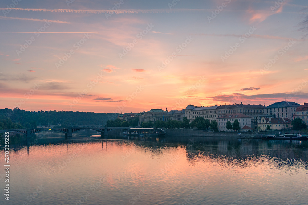 Beautiful sunrise over Vltava river with Prague cityscape