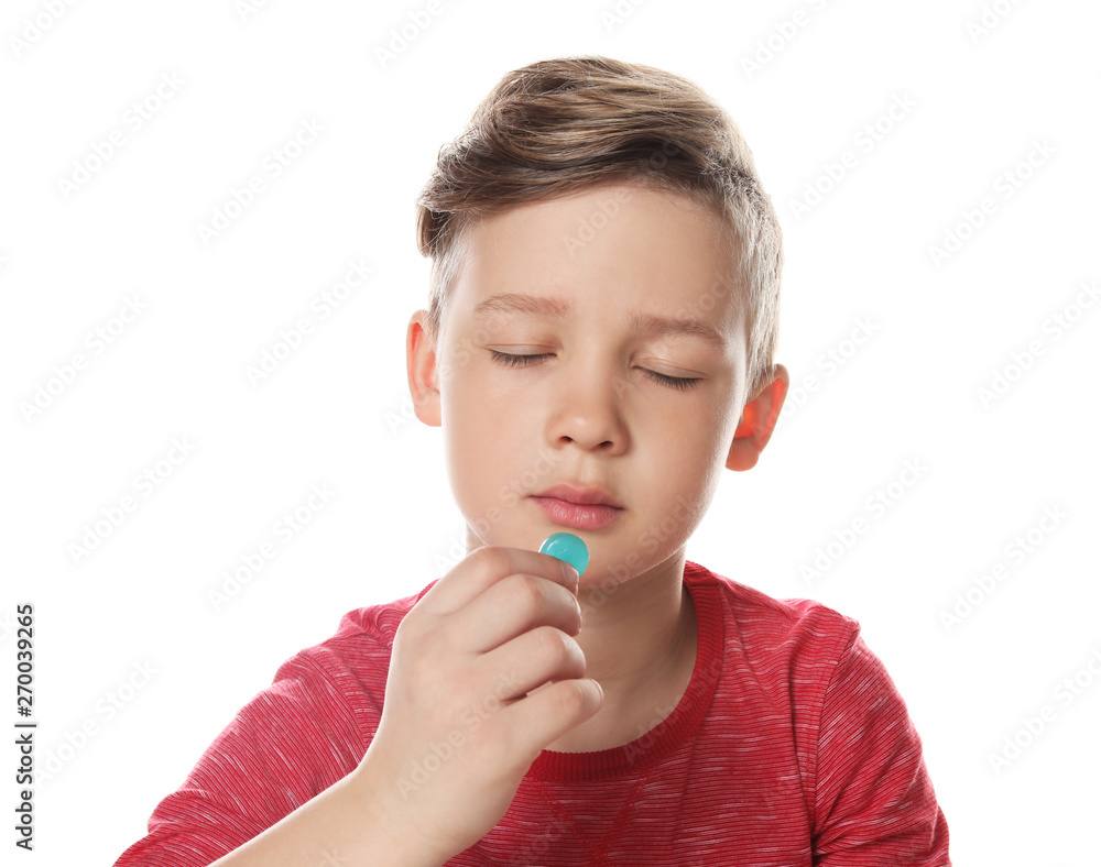 Little child taking pill on white background. Danger of medicament intoxication Little child taking pill on white background. Danger of medicament intoxication