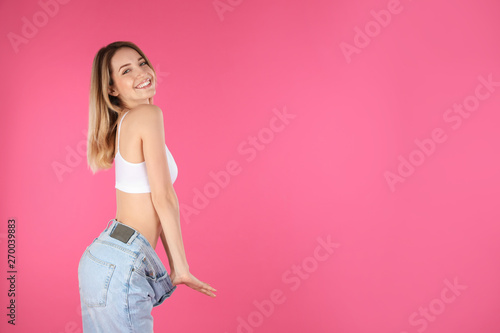Slim woman in oversized jeans on color background, space for text. Perfect body