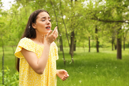 Young woman suffering from seasonal allergy outdoors, space for text photo
