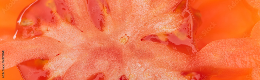 Fototapeta premium close up view of red ripe tomato half with seeds, panoramic shot