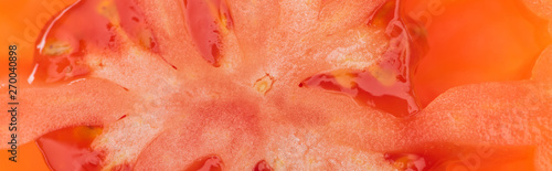 close up view of red ripe tomato half with seeds, panoramic shot