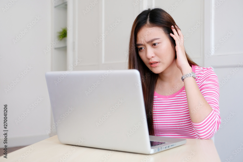 Young asian woman with frustrated expression while working with laptop computer, working from home, casual office lifestyle Young asian woman with frustrated expression while working with laptop computer, working from home, casual office lifestyle